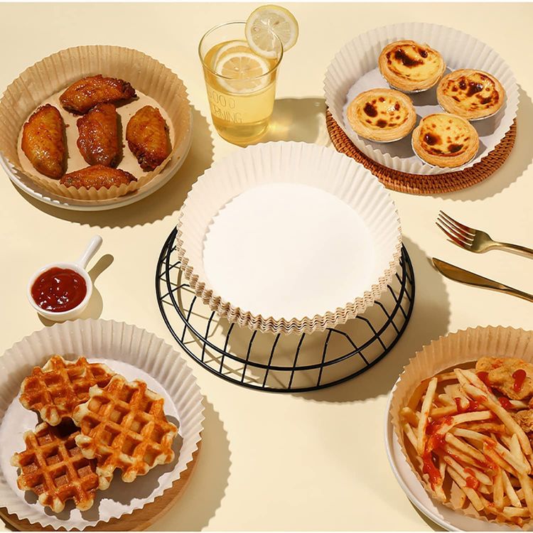 A group of disposable air fryer paper liners with food in them