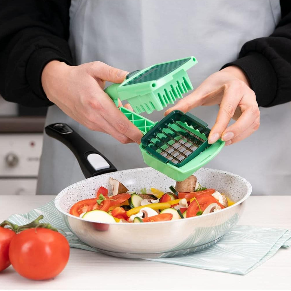 Person using a green vegetable chopper over a bowl of chopped vegetables on a kitchen counter.