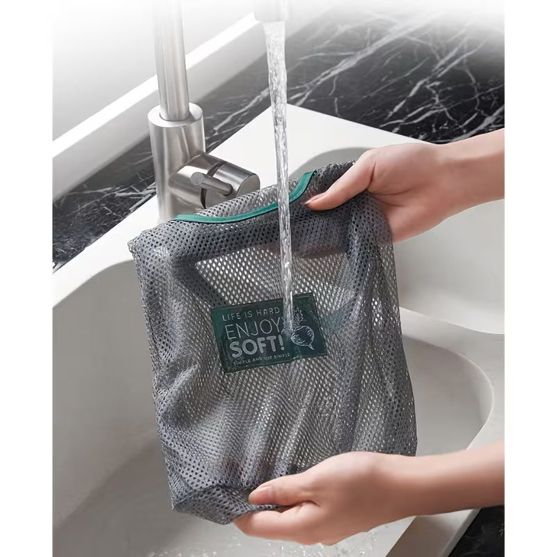 A person is washing hanging mesh storage bag with multiple compartments 