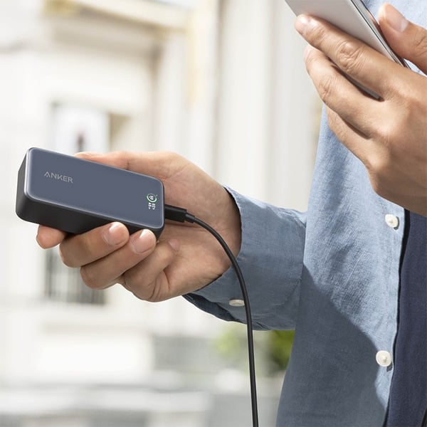 A Person is Holding Mobile Phone Connected With Anker 533 Power Bank 10,000mAh(PowerCore 30W) Series 5 - A1256H11.
