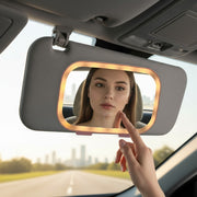 Car sun visor vanity mirror with LED lights, Reflecting a woman. 