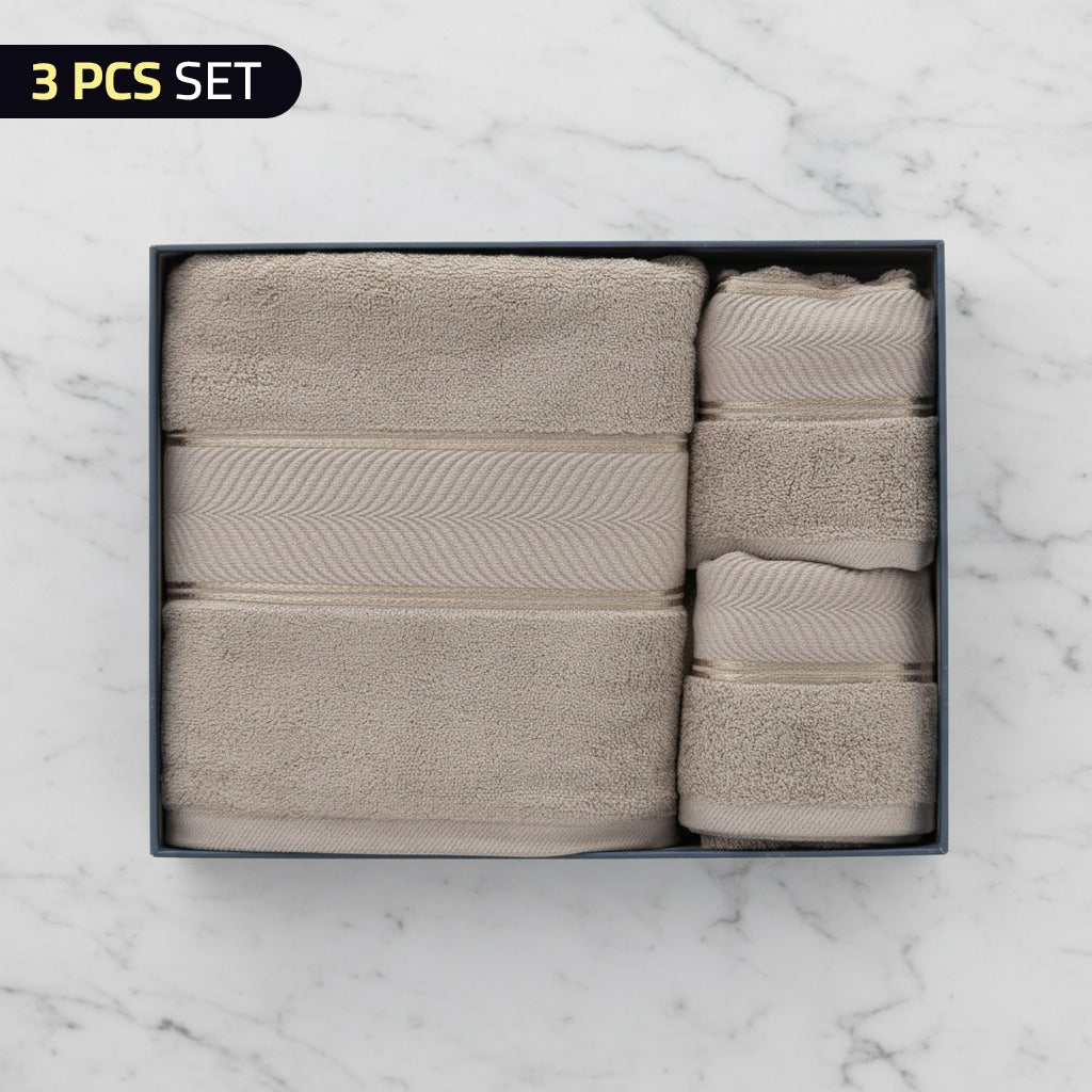 Set of three beige Cotton Bath & Face Towel Set in a box on a marble background