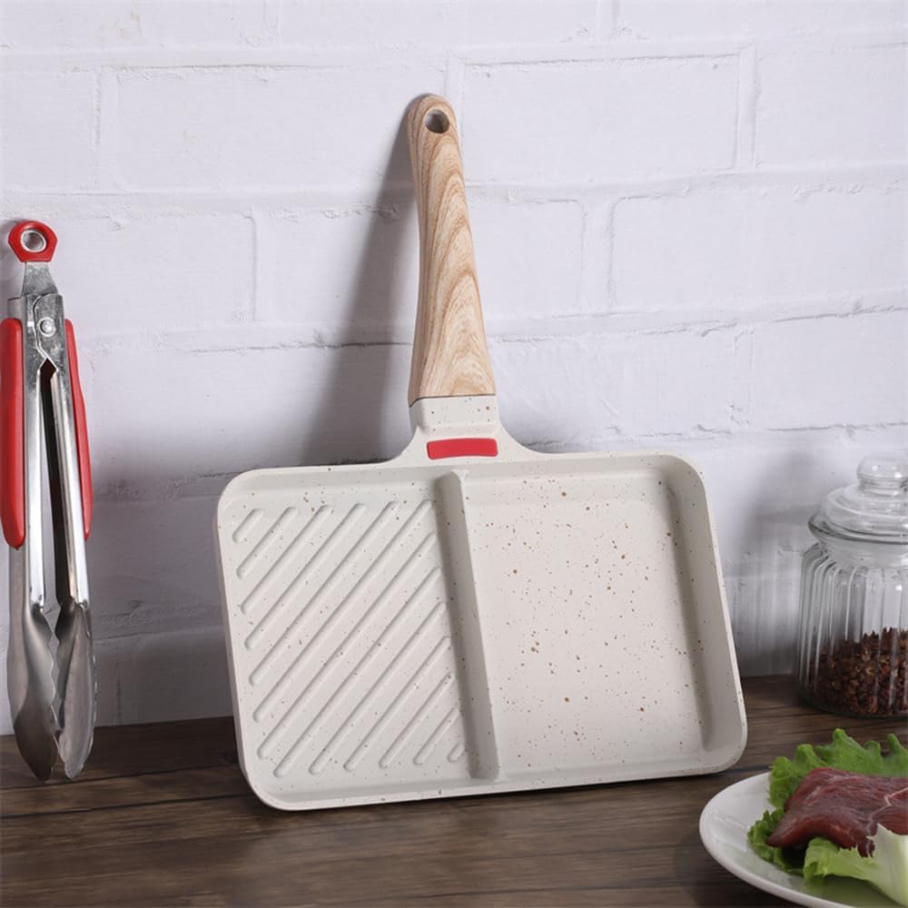 White frying pan with wooden handle on a wooden surface with a white brick wall background.