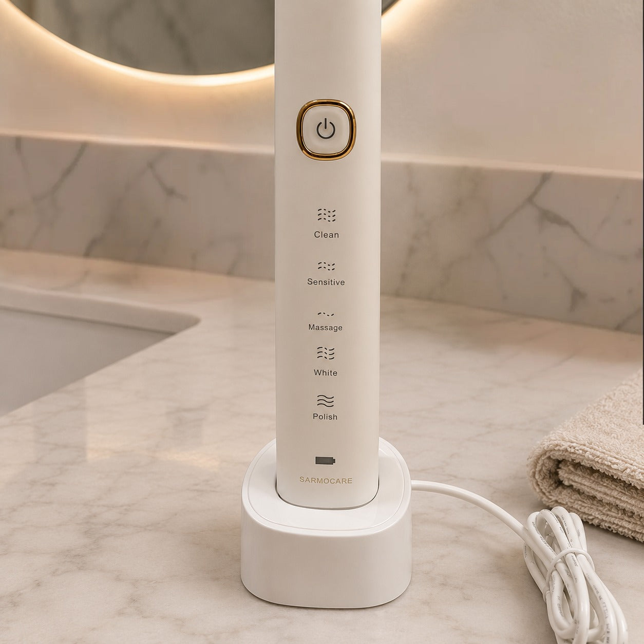 White electric toothbrush with control buttons on a marble surface
