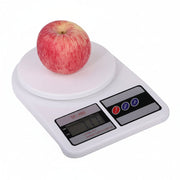 A digital kitchen scale with a fresh apple, displayed on a clean white background.