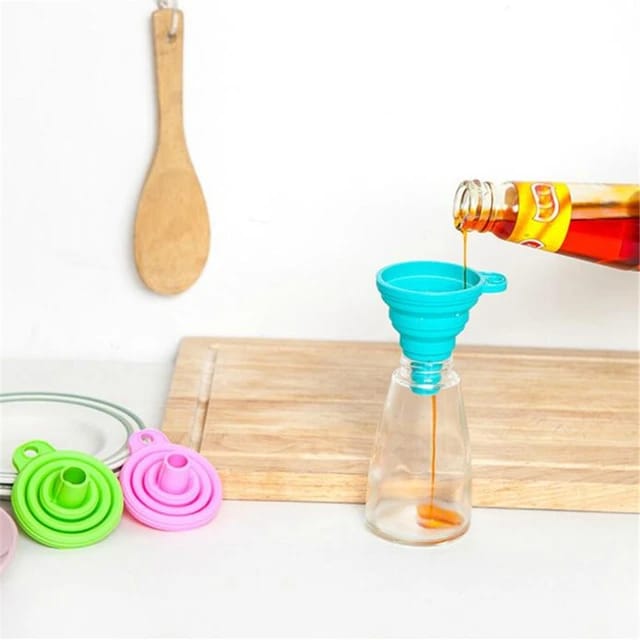 A person pouring oil into a bottle using a Silicone Telescopic Collapsible Mini Funnel