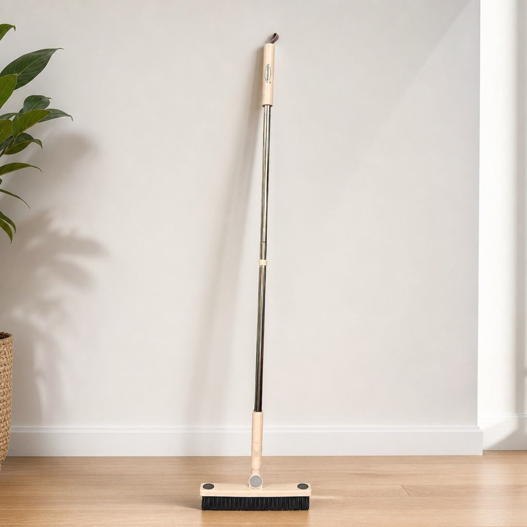 Floor Gap Cleaning Brush with extendable handle on a wooden floor against a white wall.