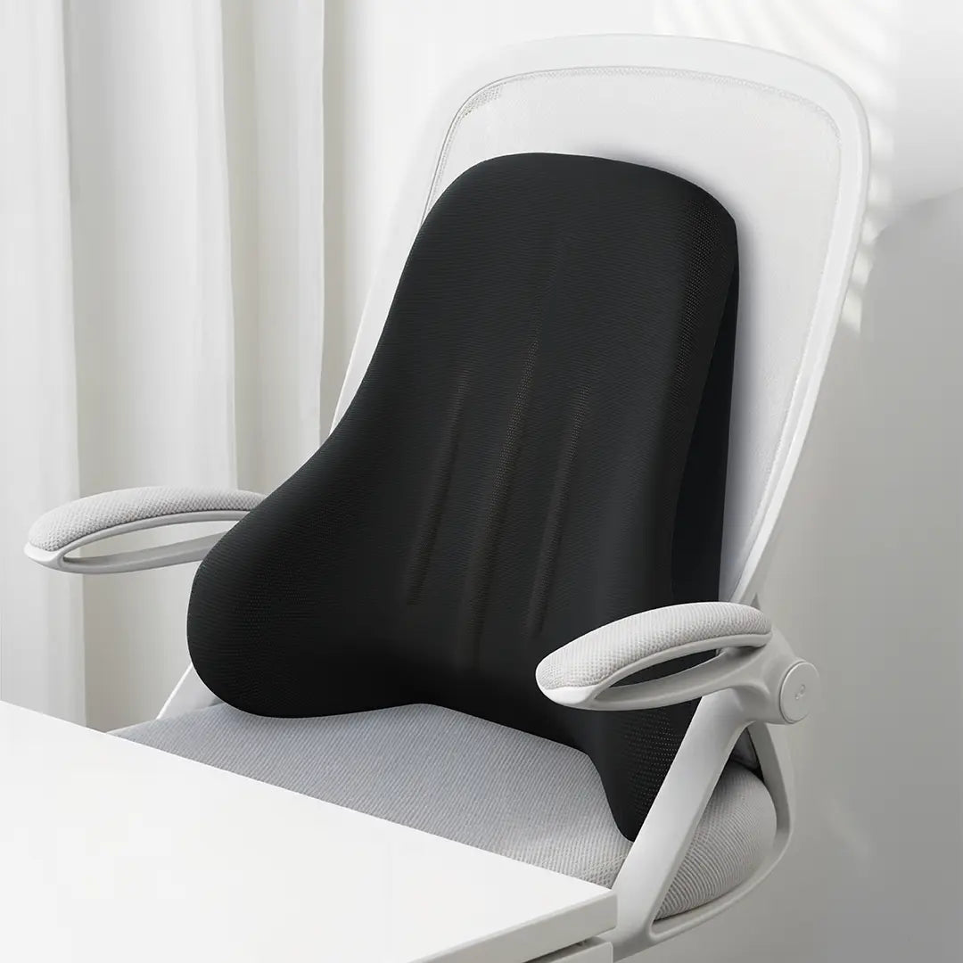 The Green Lion Comfort Mate Seat Cushion placed on a white office chair, set against a soft white curtain background.