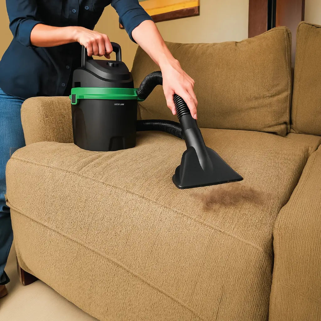 Person using a Green Lion Force Vacuum 6L Wet & Dry Vacuum Cleaner on a brown couch