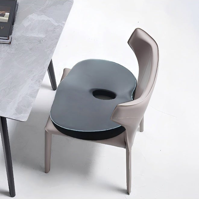 Modern chair with a Green Lion Cloud Plus Memory Foam Seat Cushion next to a marble table on a white background