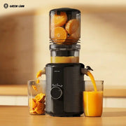 Green Lion Slow Juicer Pro Cold Press Juicer with oranges being juiced into two glasses on a wooden surface.