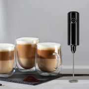 Handheld Electric Milk Frother is Placed Along with Cups of Drinks.