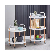 Multi-tier mobile storage table placed on the floor in front of the wall arranged with food