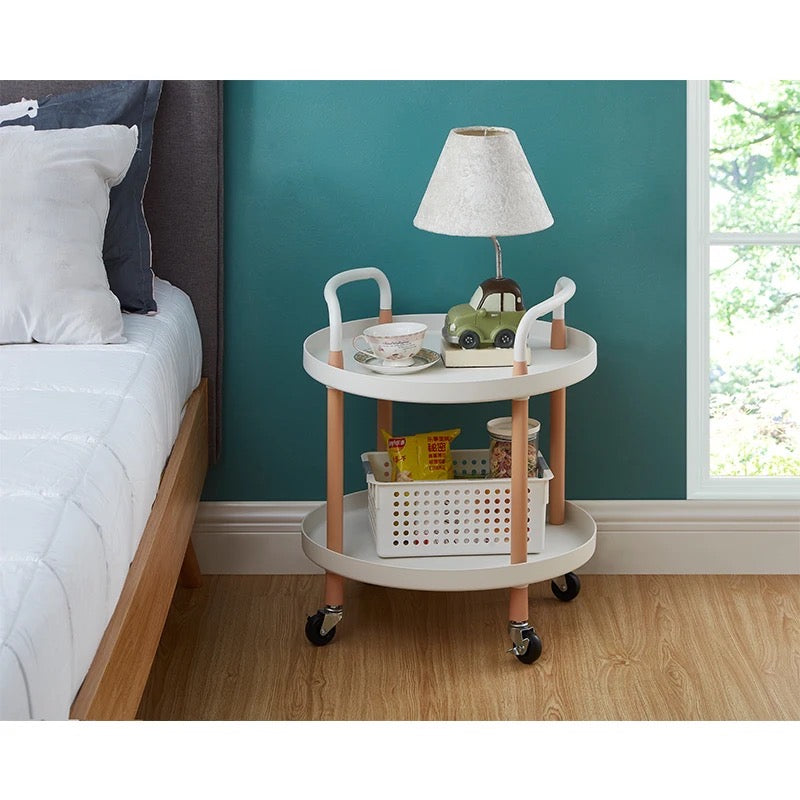 Multi-tier mobile storage table placed on the floor next to the bed