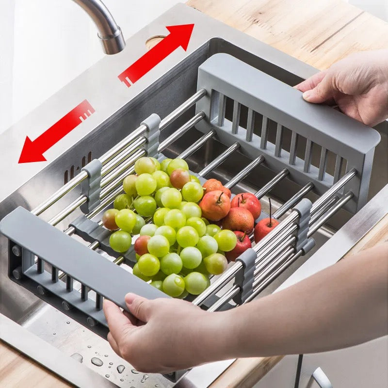 Someone pulling an expandable dish drying and washing basket