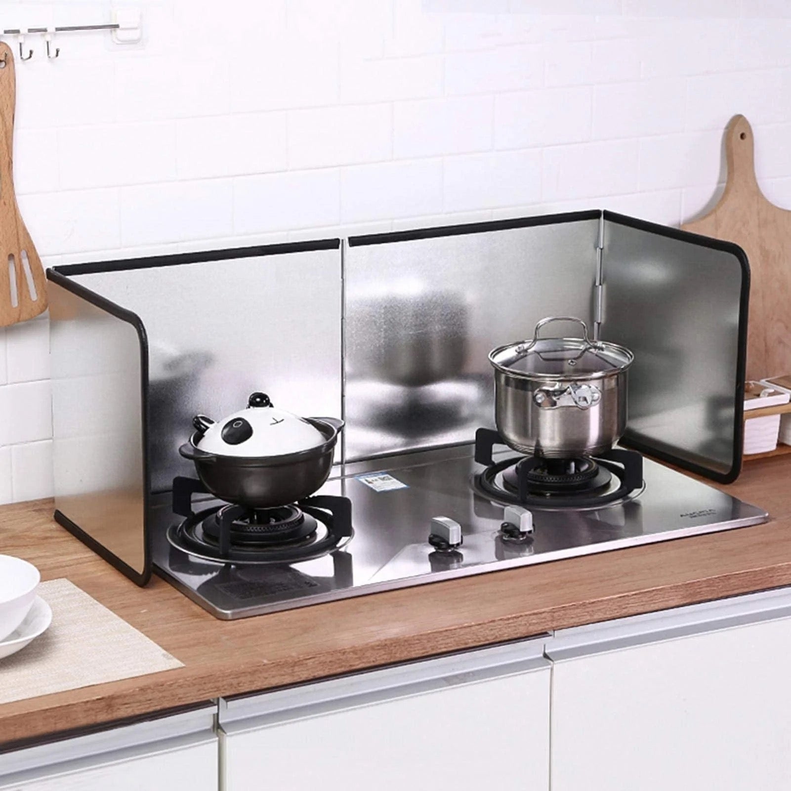 a stove with a couple pots on top protected by Gas Stove Oil-blocking Board