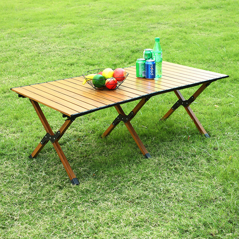 Outdoor Portable Camping Table with fruits and soft drinks kept on top of it situated in a park for picnic 