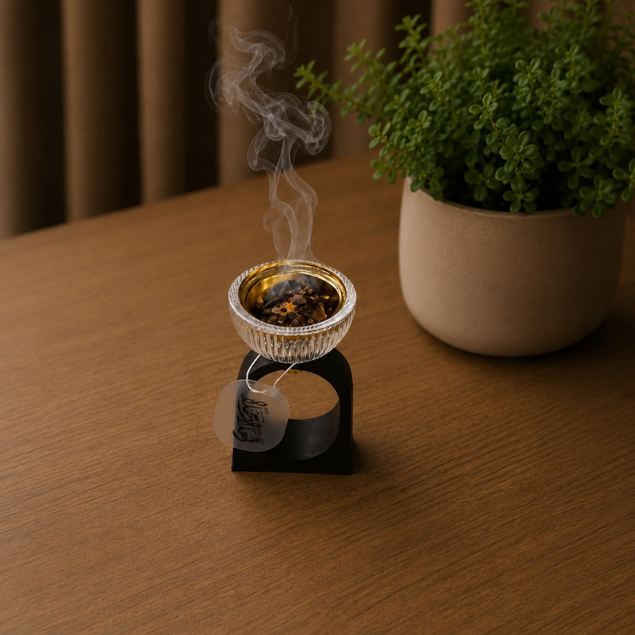 Incense burner with smoke on a wooden surface next to a potted plant