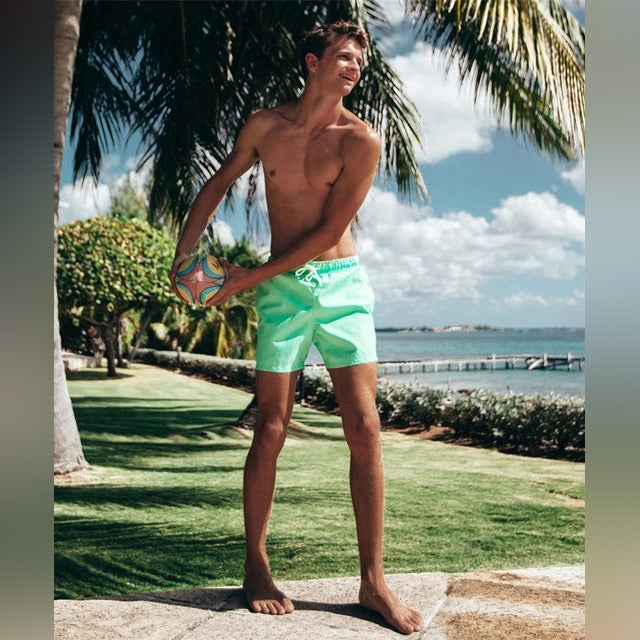 A Person is Wearing Men Color Changing  Beach Shorts.