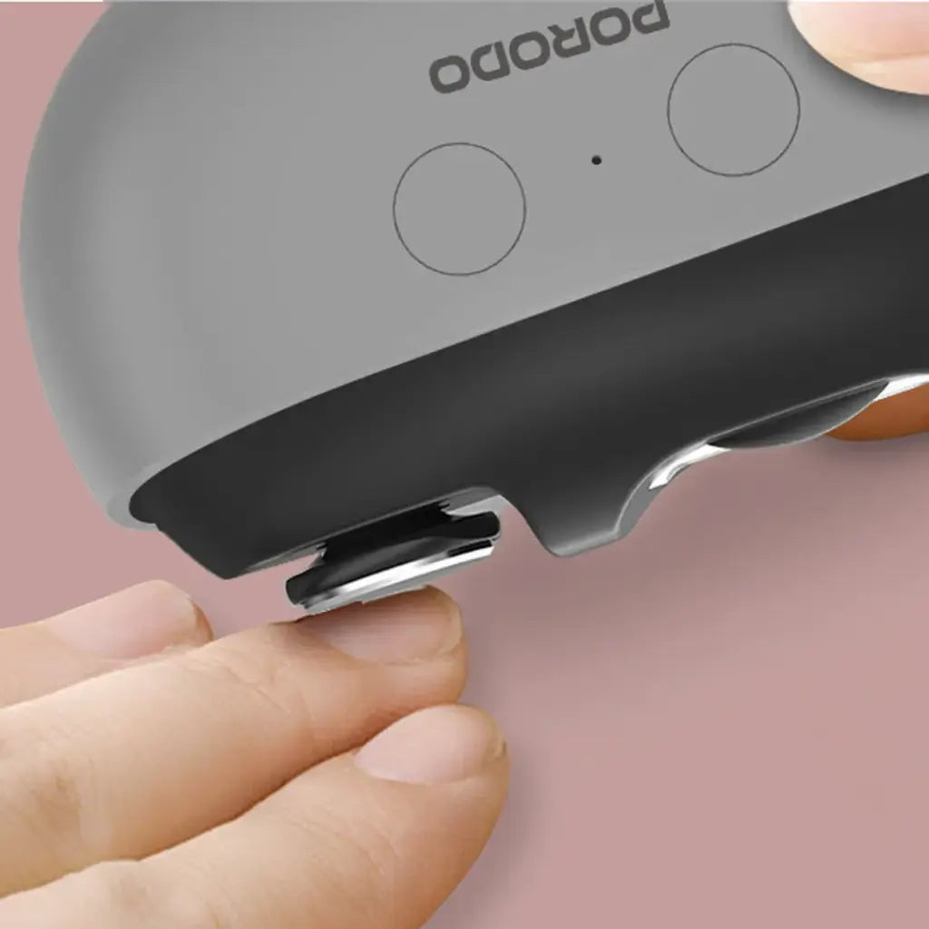 Porodo Multi-Function Electric Nail Clipper held by a hand against a pink background