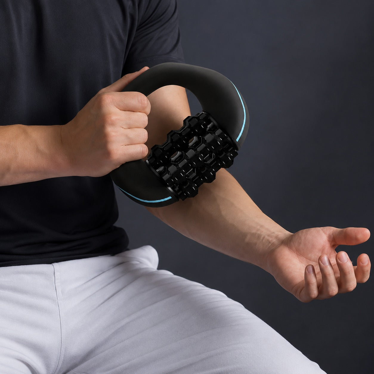 Person using a black Porodo Relieva Roller Massager on their arm against a dark background