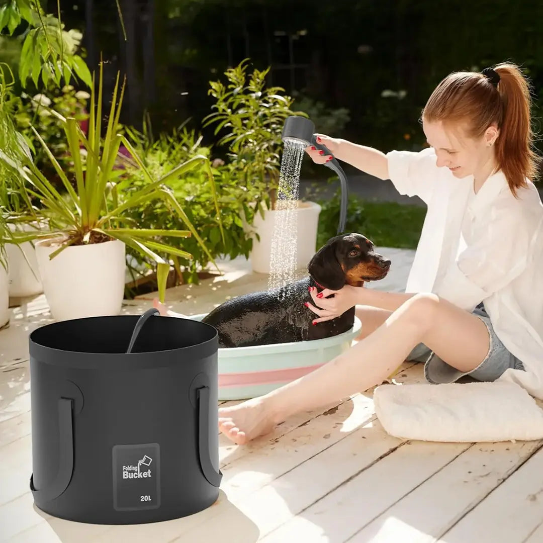 Woman washing a dog in an outdoor setting with a Green Lion Portable Camping Shower