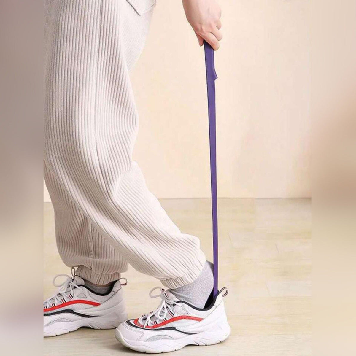 A Person is Wearing Shoe Using Long Handle Shoe Horn.