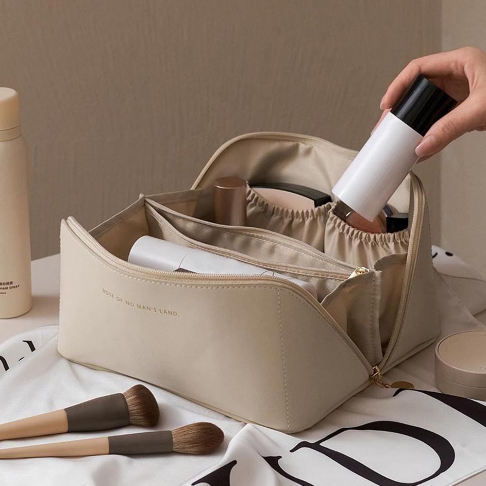 Someone is putting something into the Large Capacity Foldable Travel Cosmetic Bag