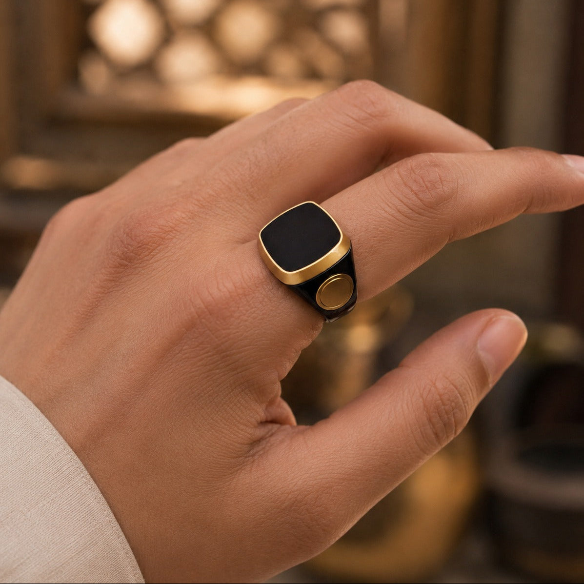 Hand wearing a Smart Tasbih Ring Counter with a blurred warm-toned background