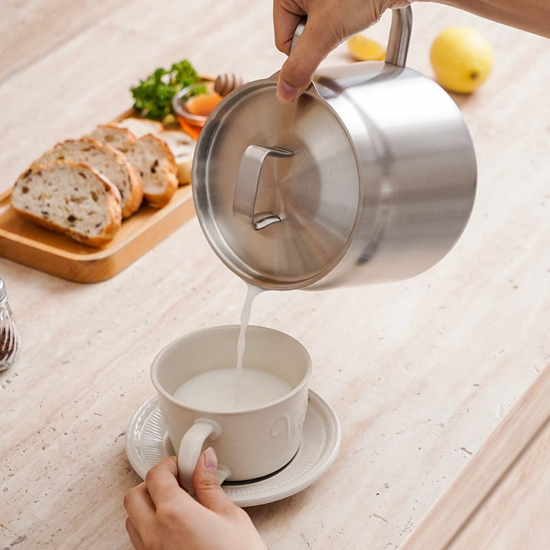 A Person is Taking Milk From Stainless Steel Oil Strainer Storage Pot.