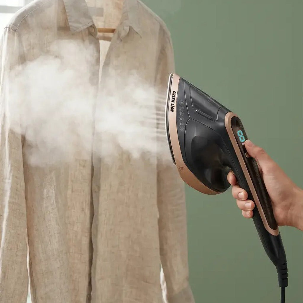 Person using a steam iron on a beige shirt against a green background