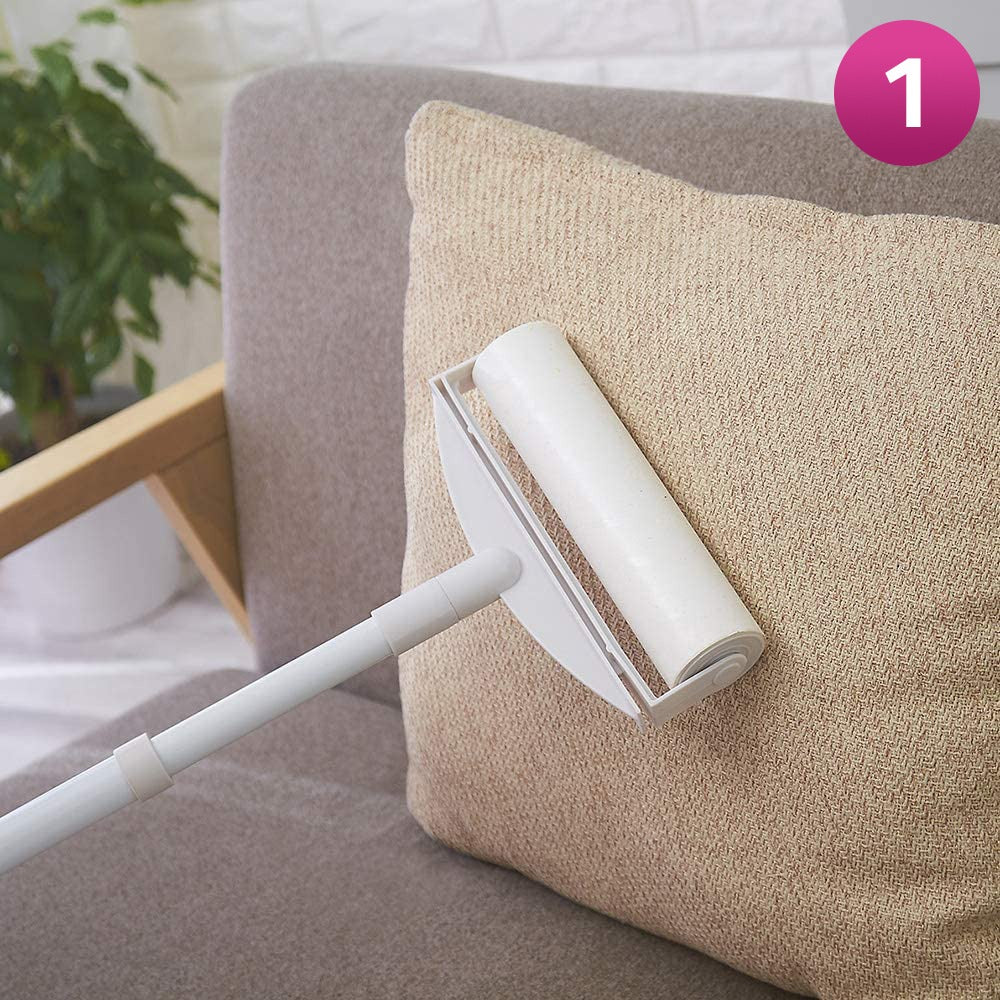 A Sticky Mop with a long white handle is shown cleaning a beige textured throw pillow on a gray sofa. A pink circular badge with the number 1 is in the top right corner.