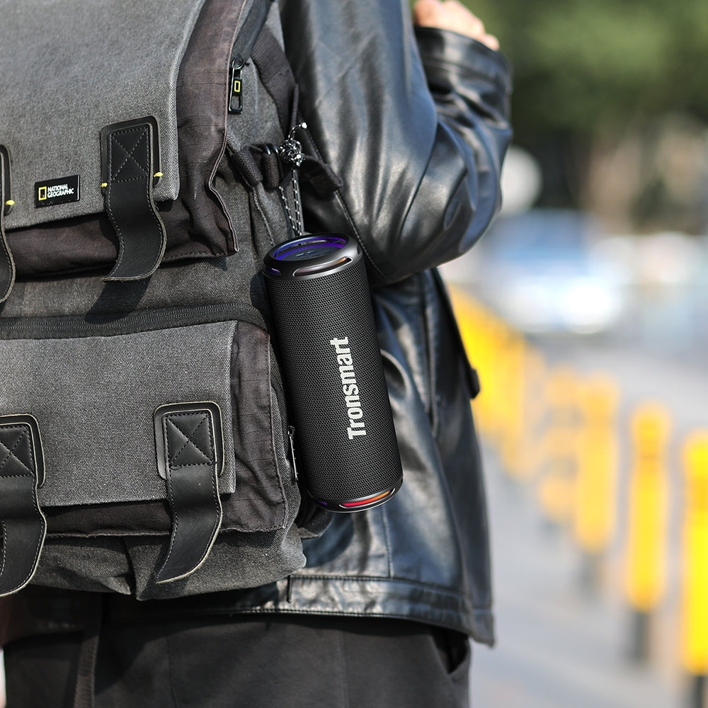 A Person is Attached Tronsmart T7 Lite Portable Outdoor Speaker on his Backpack.