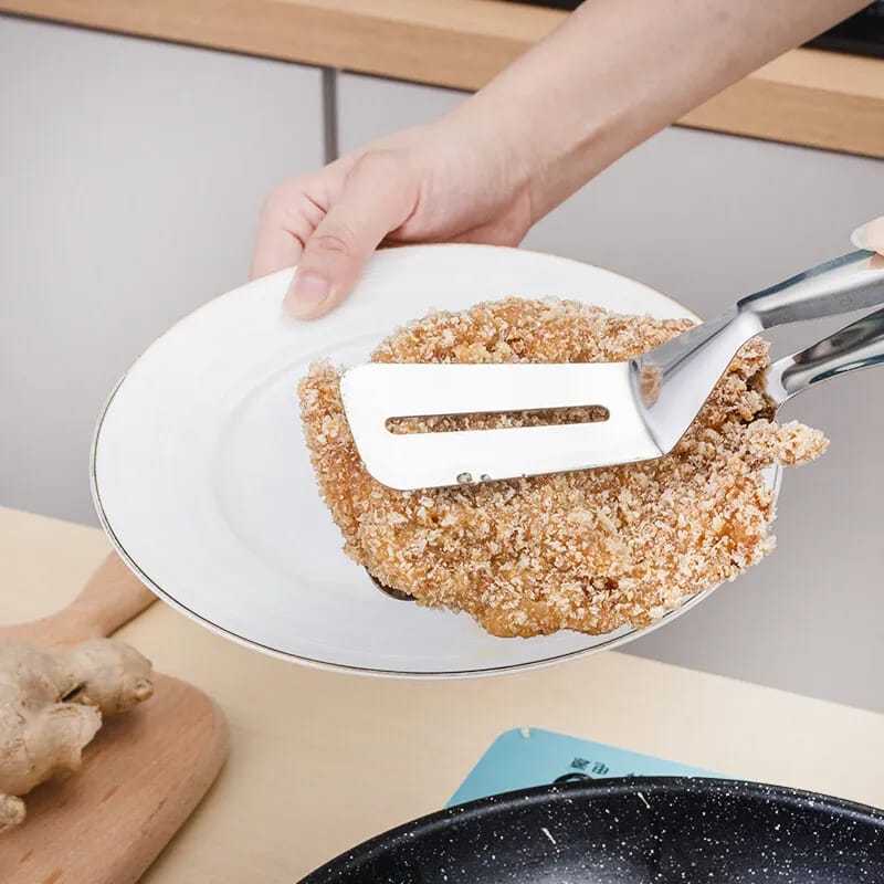 Someone putting something into a plate with the help of Stainless Steel Food Tongs