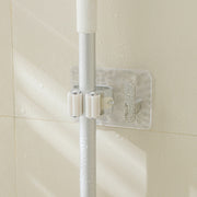 A Wall-Mounted Mop & Broom Holder is Holding Mop Fixed on a Bathroom Wall.