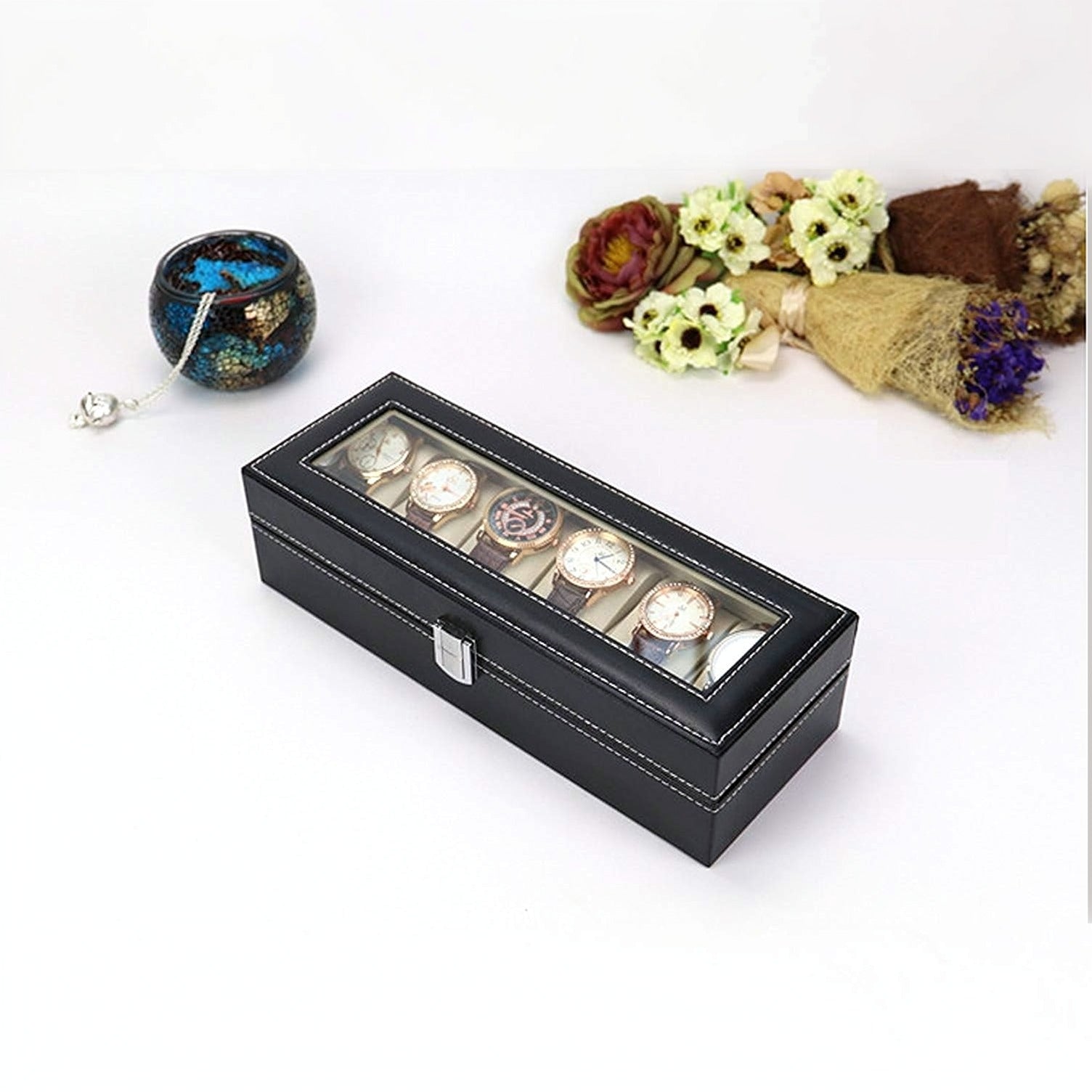 Black watch box with six watches on a white background with decorative elements.