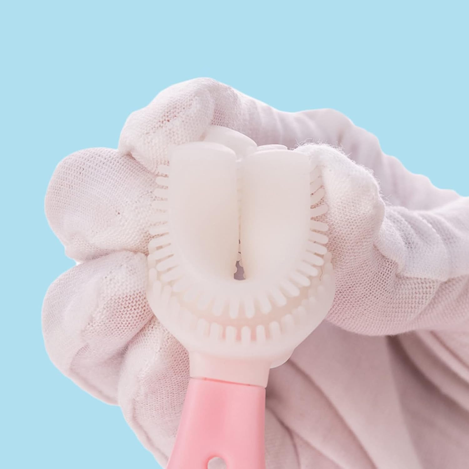A person holding a U-shaped kids toothbrush on it's head