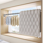 Cloths and a blanket hung on Extendable Tension Rod mounted on a window frame 