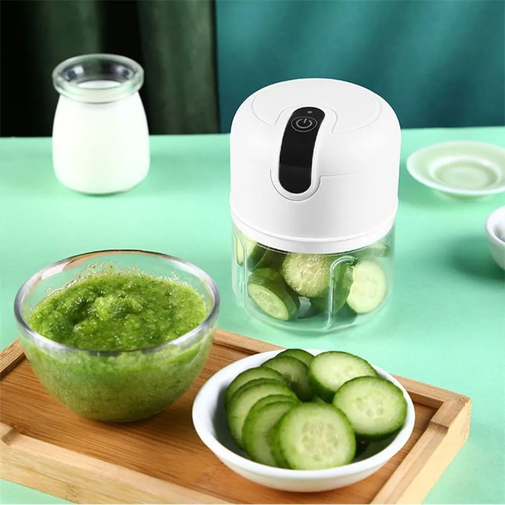 Mini Electric Chopper Food Processor placed  on the table next to ingredients in bowls