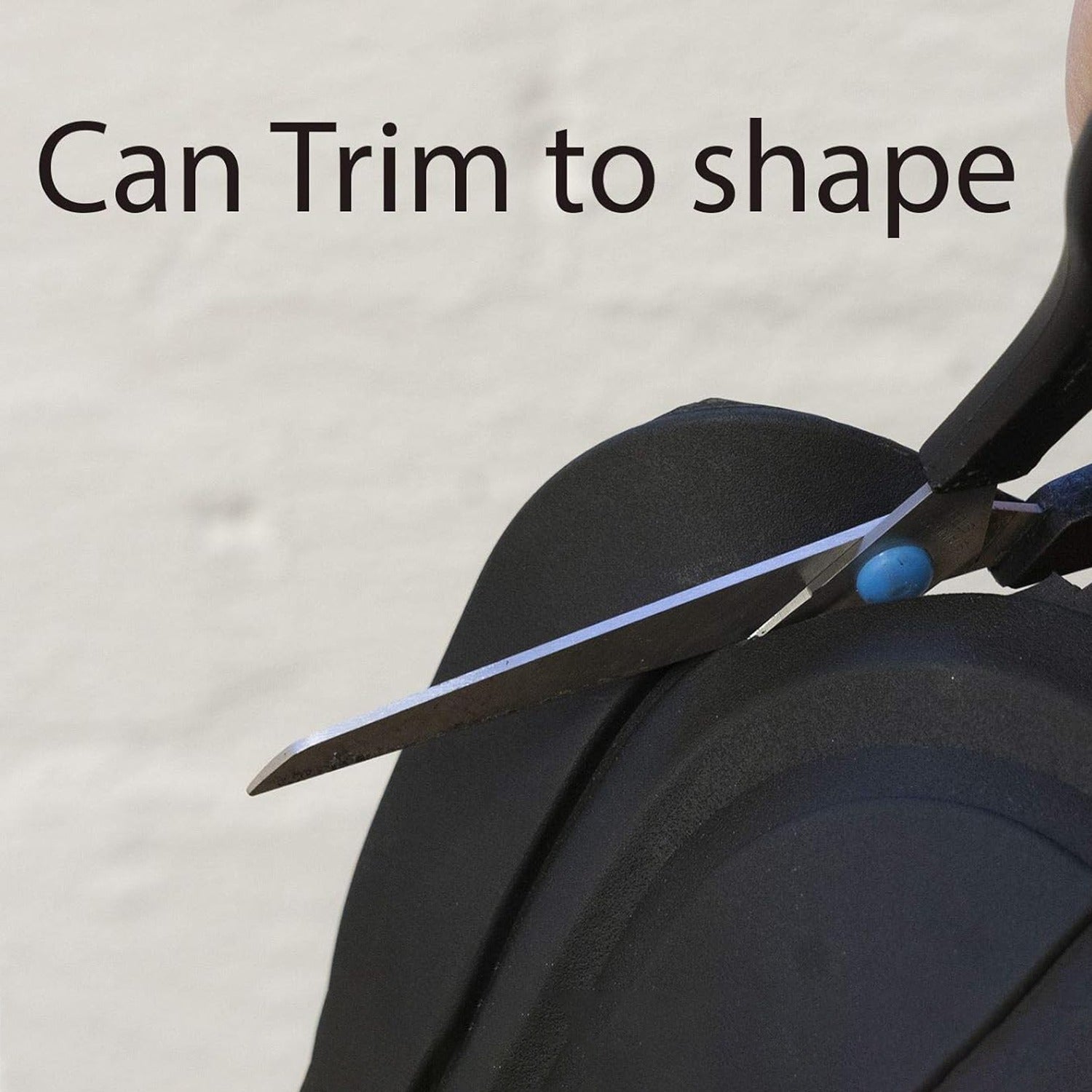 Scissors cutting a piece of car floor mats with text 'Can Trim to shape' on a beige background