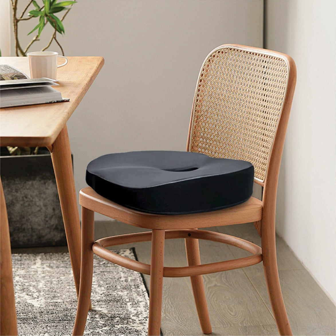 Green Lion Cloud Plus Memory Foam Seat Cushion on a wooden chair in a room with a table and plant.