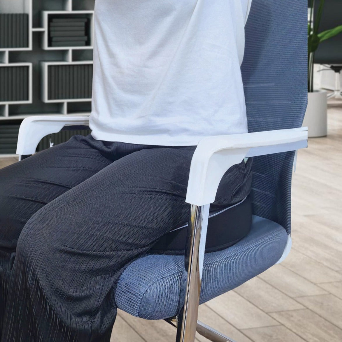 Person sitting on a blue office chair with Green Lion Cloud Plus Memory Foam Seat Cushion in an indoor setting.