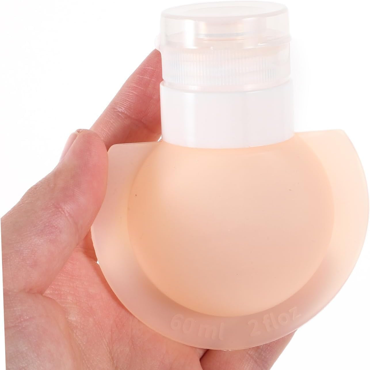 Hand holding a Silicone Travel Bottle Set with a white cap on a white background