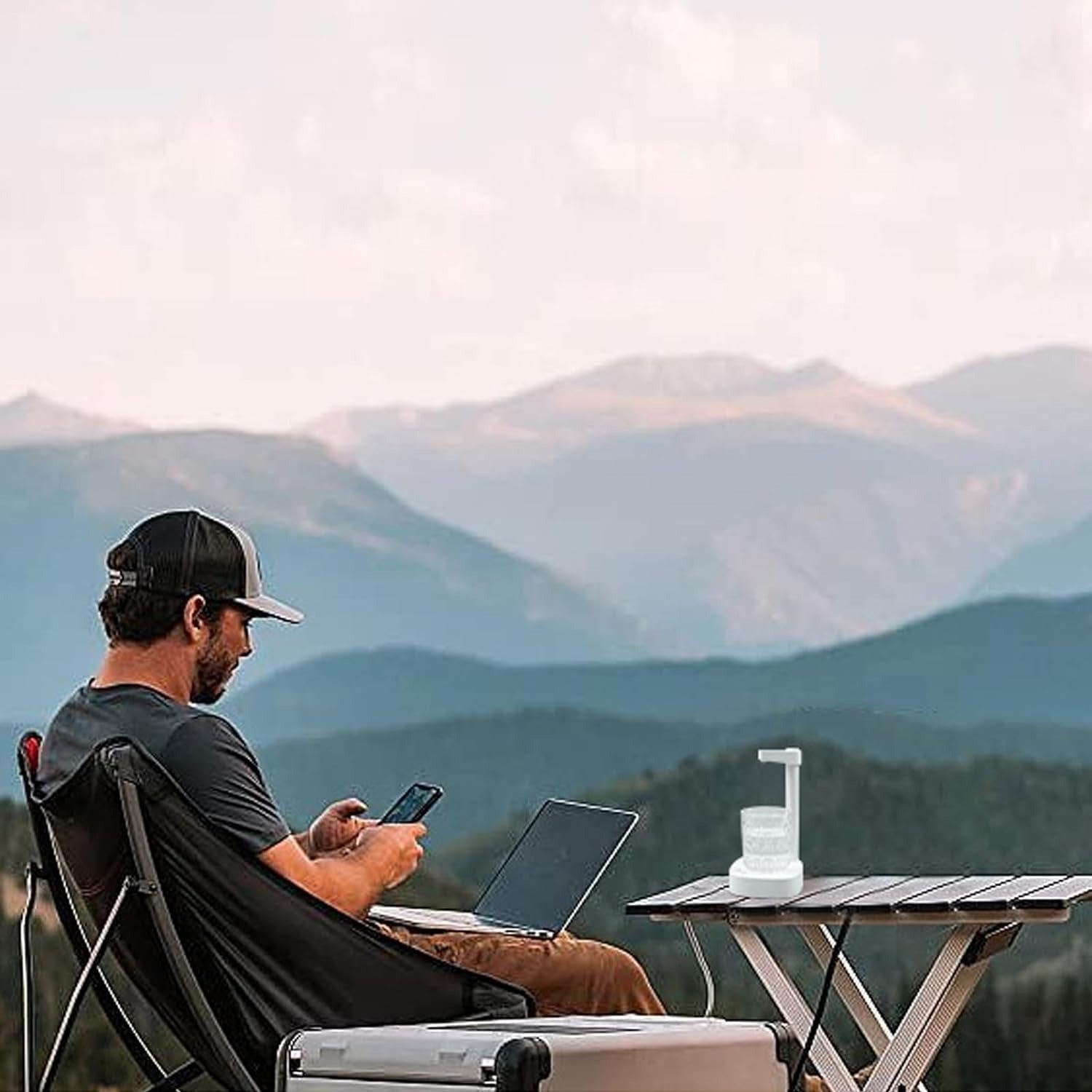 a man working on laptop while traveling with travel friendly water dispenser